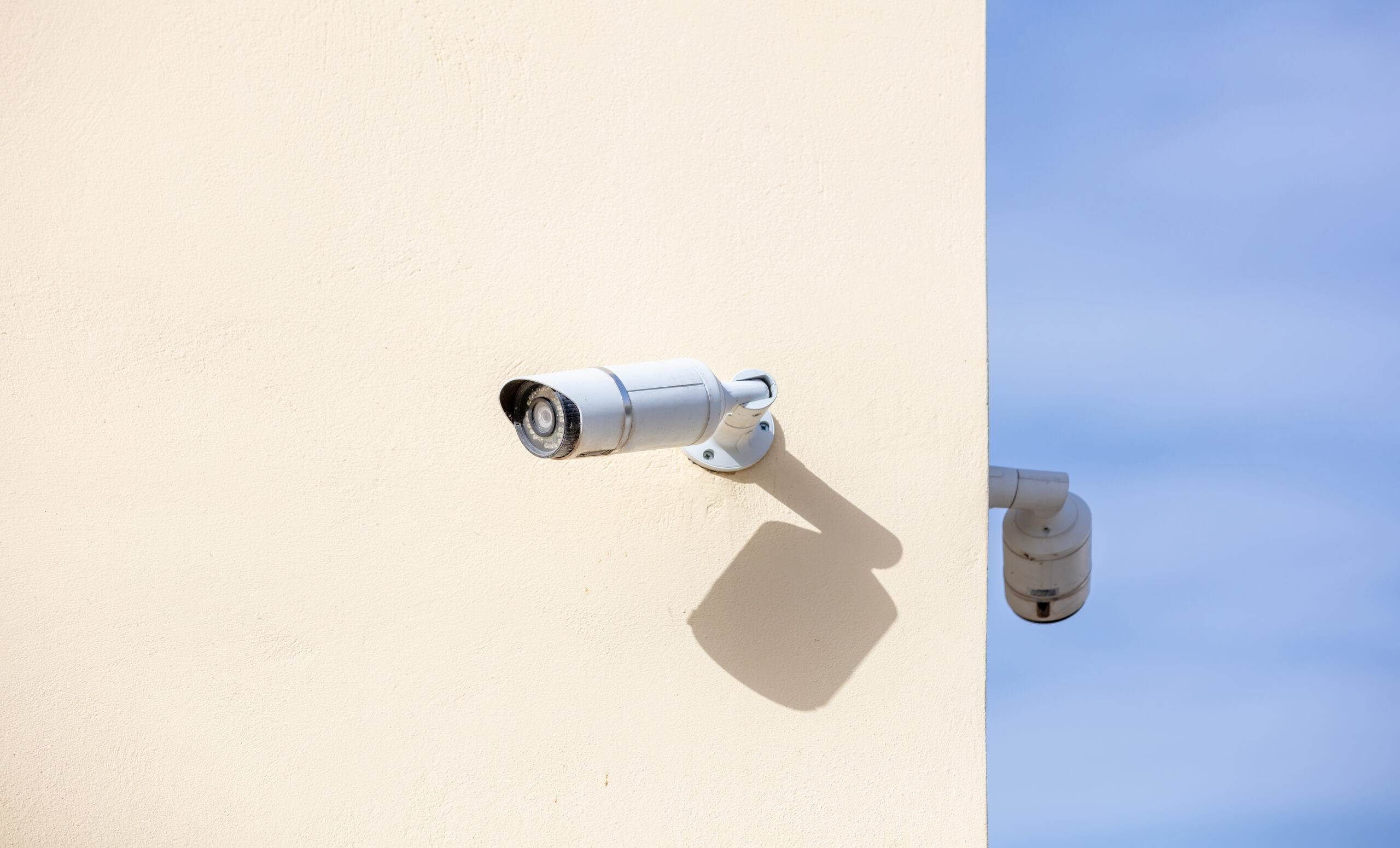 CCTV Cameras, Security system. Surveillance cams on painted wall, bkue sky background, copy space